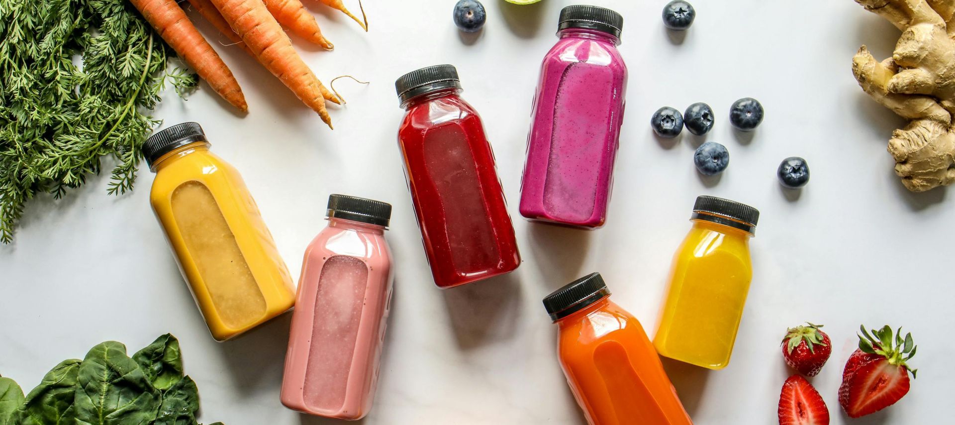 Colorful assortment of organic juices with fresh ingredients for a healthy lifestyle.