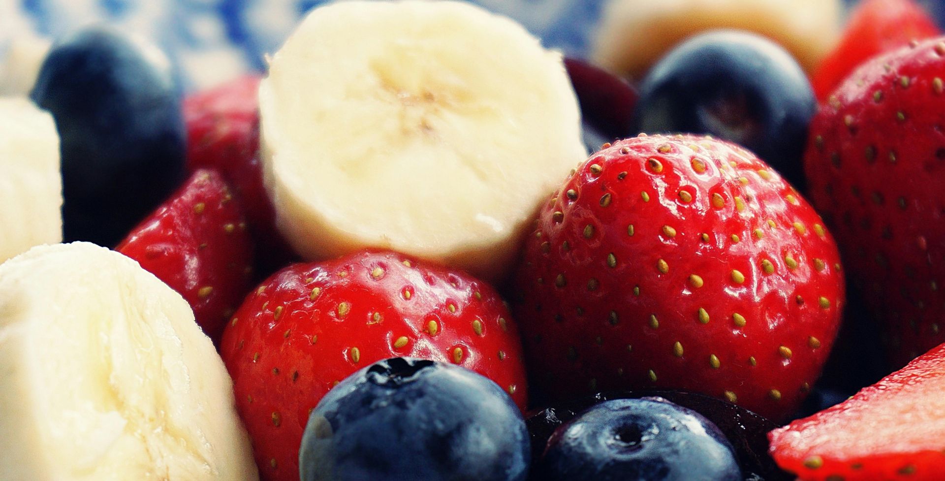 Close-up of fresh bananas, strawberries, and blueberries. Perfect for health and diet themes.